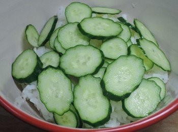 step6: 白飯上放小黃瓜薄片，再蓋上炒好的打拋肉片