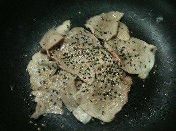 step3: 待豬肉片兩面都已由紅色轉為白色時，灑入黑芝麻及白芝麻，再翻炒一下，芝麻燒肉片就完成了。