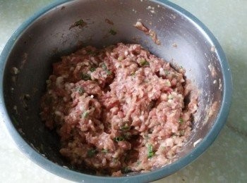 step1: 豬肉餡中加入黃酒、姜粉拌均勻，再分次加入清水，每次等水完全吸收加下壹次，直至肉餡吸足水分，順同壹方向攪打上勁直至起膠。最後再加入鹽、生抽、老抽、香蔥、色拉油、香油拌均勻。