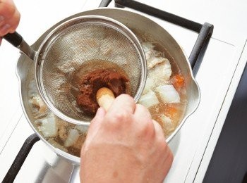 step6: 用味噌濾網過濾紅味噌，將紅味噌溶入鍋中，煮約5分鐘，使<span class="group_1">食材</span>入味。