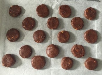 step5: 把麵團分成小份，約20g一份。滾圓後放在已鋪上牛油紙的烤盤上，輕輕壓平。