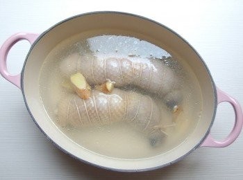 step5: 將汆燙過的雞腿及薑片放入鍋裡,注入適量的水(水量超過雞腿的高度即可),水滾後轉小火,蓋上鍋蓋煮約15分鐘,熄火後用餘溫燜熟放涼即可。