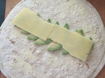 step2: 將牛油薄薄塗在墨西哥薄包上
再將牛油果片、芝士、火腿，順序鋪在麵包上中間位置