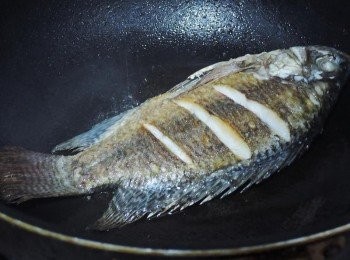 step1: 吳郭魚兩面魚身輕畫三刀，鍋子熱後，下兩大匙油，順一下鍋子，就可以下鍋煎魚囉!!!煎魚沒有技巧，只要注意，一面煎熟後，再翻面，熱鍋冷油不沾鍋