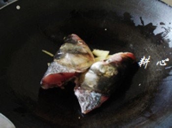 step3: 原鍋熱油，放入薑片和魚頭，煎至雙面。
