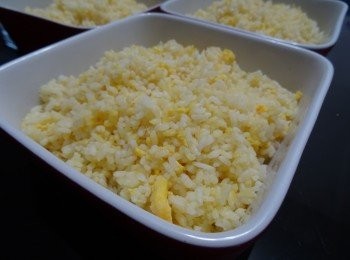 step5: (1）用一大易潔鑊，下少許油後將冷飯放進鑊中, 將飯炒散          ( 2) 鑊中央開一小洞，加少許油，將蛋汁放進，但開始夾結皮時，將飯快速兜炒
         (3)最後下糖，鹽調味便完成。(4)將飯放盛在焗盤內備用
