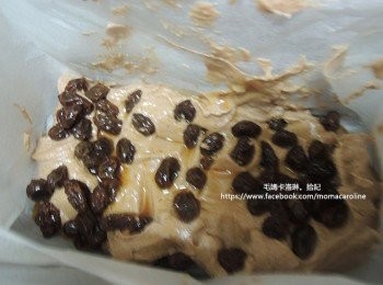 step6: 準備烤模，將烘焙紙墊好之後，放入1/3的麵糊，接著放入1/2的葡萄乾，再放少許麵糊再放剩下的葡萄乾，最後再放一層麵糊。盡量將葡萄乾包覆在麵糊裏，因為露出的葡萄乾容易因為烤過之後微苦。