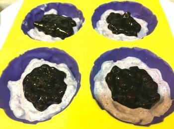 step8: 雪糕冷藏了1小時後，便可取出加入朱古力模中，先加雪糕到一半位置，跟住加 1茶匙即食藍莓果醬係中間，再加入雪糕至9成滿左右，然後放入冰格冷藏多2-3小時