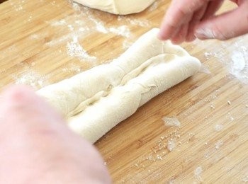 step5: 再將下半的麵糰向中間摺，同樣用手輕壓接口。將麵糰拉長，輕輕壓平，再重複步驟4的動作一次