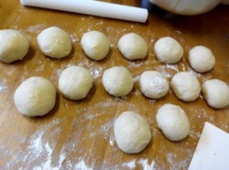 step2: 2、发好的面团分成23个小面（大小個自喜歡）团松驰15分钟，取一个小面团擀成椭圆形，抹在适量红豆沙，从一端卷起面团捏合接口。