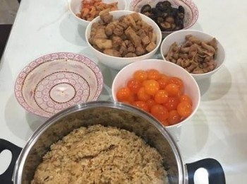 step9: 生的鹹蛋黃用少許米酒噴灑去腥。 架好吊繩，地上鋪好報紙，拿出預先洗好瀝乾的粽葉開始綁粽子。準備一碗水，壓米時手要沾水才不會黏手。綁粽子時要勒緊，粽子才會Q。 包粽子的同時可以先將深鍋裝水煮滾，方便等一下綁好就可以蒸粽子。