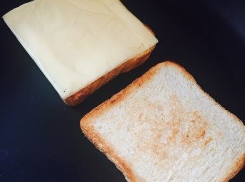 step3: 用焗爐或白鑊將麵包烤脆，先將一面烤至金黃，翻面後在其中一塊麵包上放上芝士，以慢火將芝士烘溶。