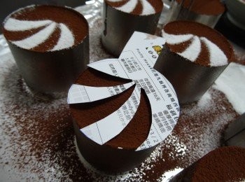 step10: Owenmama的裝飾創作版本 -------
我先灑上一層防潮可可粉， 用放上我用雜誌裁出簡單圖型， 放在餅上， 灑上防潮糖霜，唧上忌廉及放上自製朱古力葉片（用不調溫朱古力座水溶後做成的）便完成。