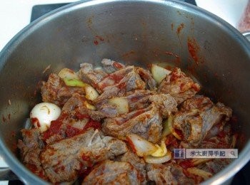 step4: 鍋中下一湯匙油，下洋蔥爆香，再下蒜頭和牛肋條，把牛肋條煎到略為金黃後，加入番茄膏炒勻。