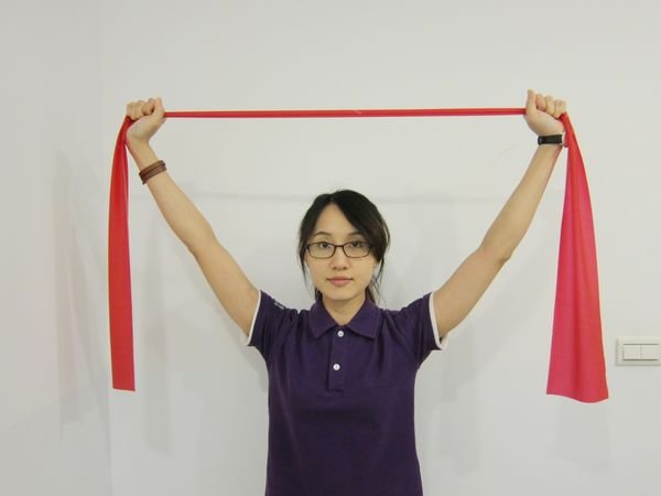 動作3：手臂維持打直與手握彈力帶姿勢，將雙手往上平舉。